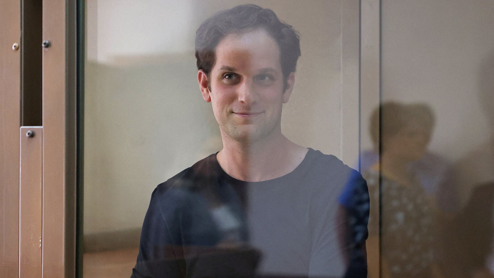Evan Gershkovich stands behind a glass wall of an enclosure for defendants before a court hearing to consider an appeal against his detention, in Moscow, Russia, June 22, 2023.