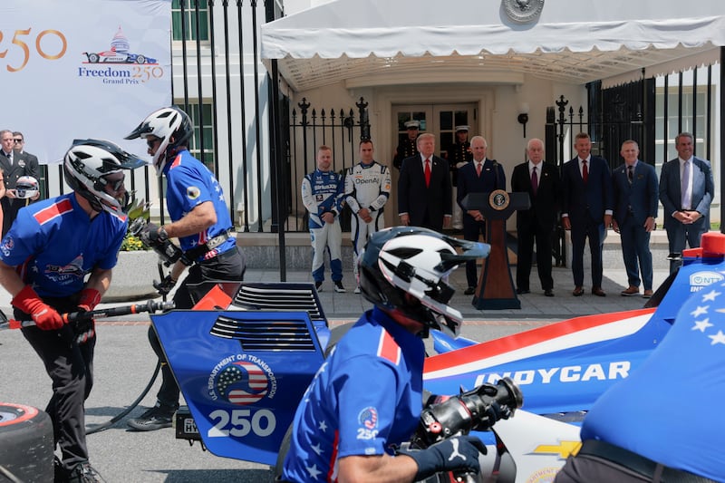 Grand Prix crew members work while U.S. President Donald Trump, IndyCar series owner Roger Penske, Freedom 250 Grand Prix Chair Bud Denker, U.S. Transportation Secretary Sean Duffy, Fox Sports CEO Eric Shanks, President of General Motors Mark Reuss, and IndyCar series drivers Alex Palou and Felix Rosenqvist look on during a Freedom 250 Grand Prix Showcase at the White House in Washington, D.C., U.S., July 13, 2026. REUTERS/Kylie Cooper