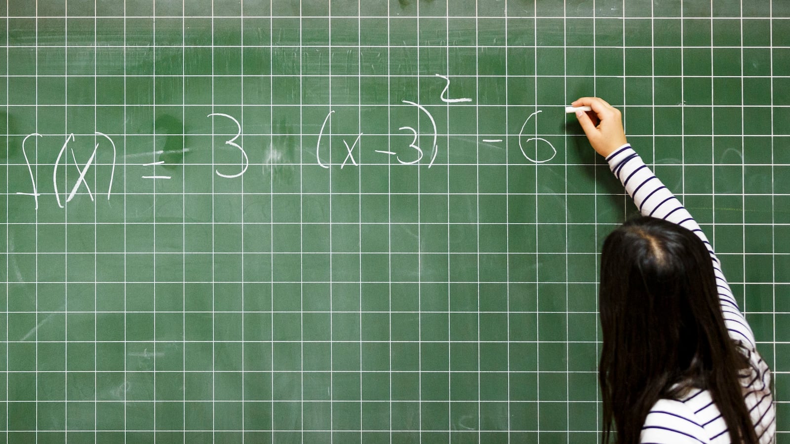 Girl solves math problem on a chalkboard