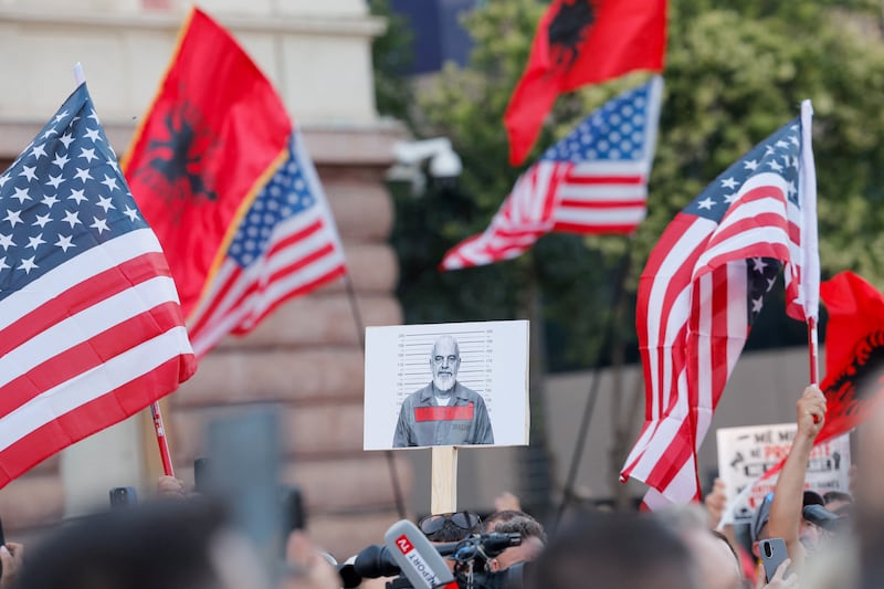 A protester holds a picture depicting Albania's Prime Minister Edi Rama as others hold U.S. and Albanian national flags during a protest against a luxury resort, a plan by a company linked to Donald Trump's son-in-law, Jared Kushner, on an environmentally sensitive part of the Adriatic coast, in Tirana, Albania, June 12, 2026.