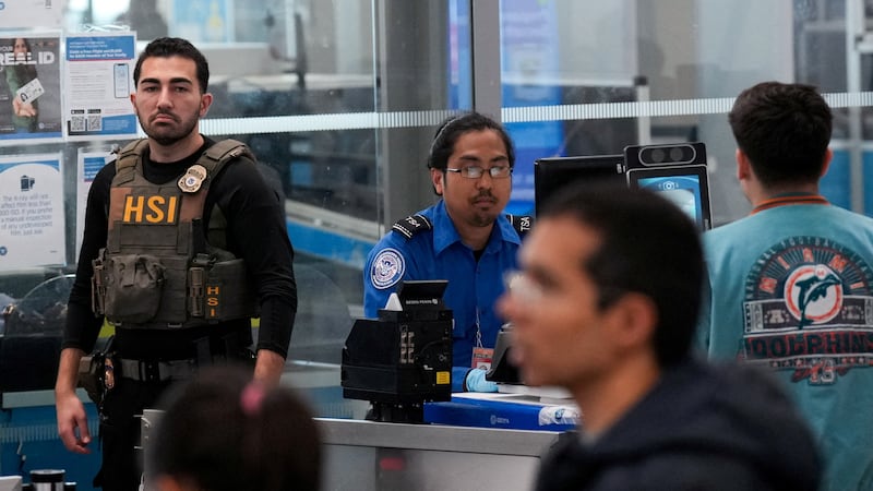 A Homeland Security Investigations (HSI) agent stands alongside a TSA officer in the TSA security area at John F. Kennedy International Airport, New York City, U.S. March 23, 2026.