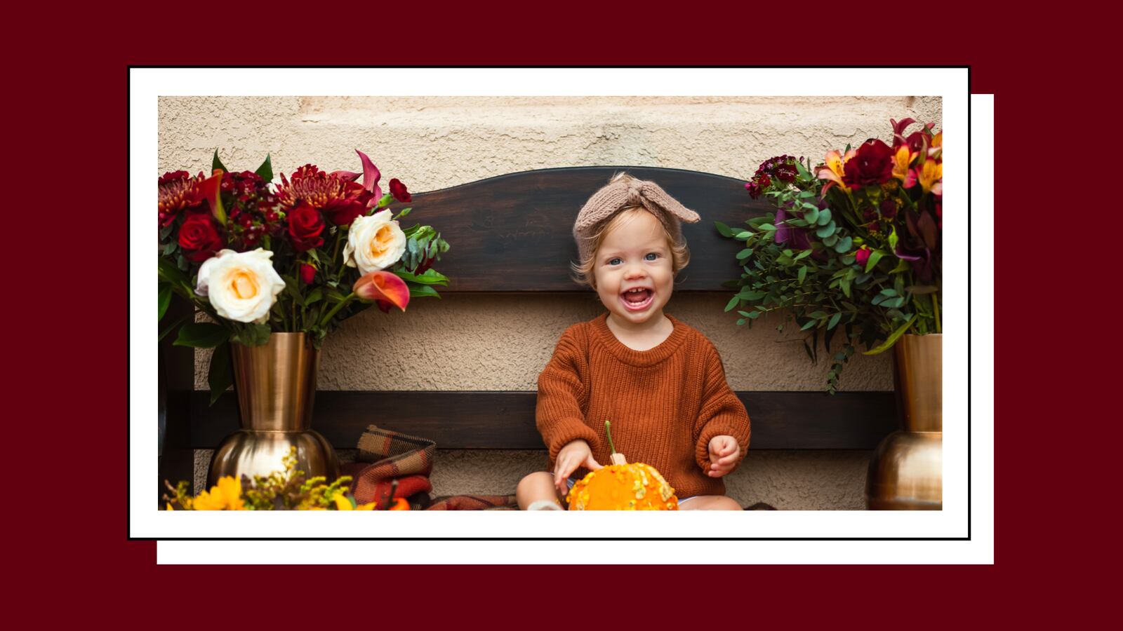 Child sitting between flowers.