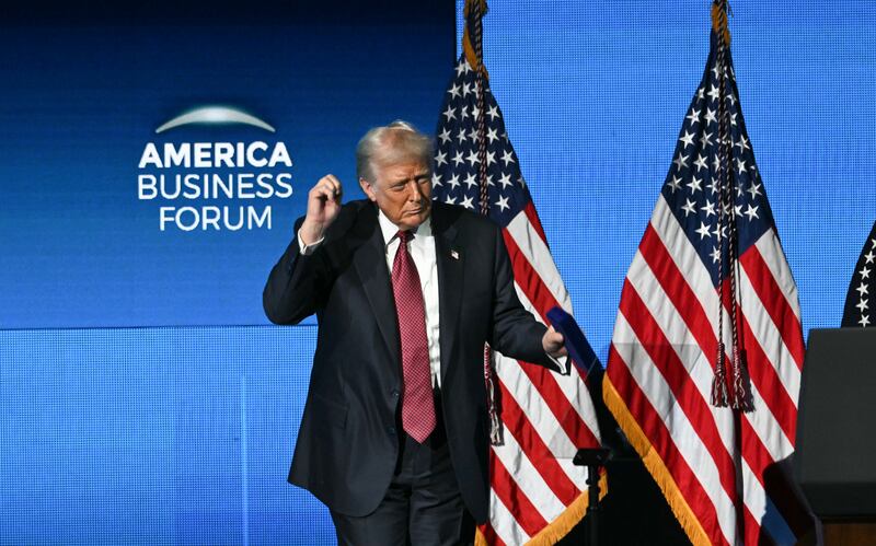 Trump dances on stage after speaking at the American Business Forum in Miami. Also on Wednesday, the Supreme Court heard arguments challenging his constitutionality of his tariffs.