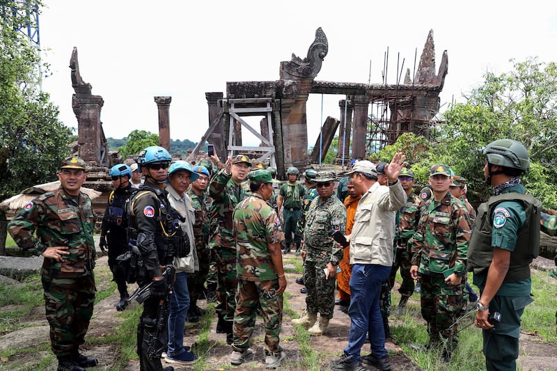 This pool photo taken and released on August 20, 2025 by Agence Kampuchea Presse (AKP) shows Cambodian and foreign military personnel speaking during a visit organized by Cambodia's Ministry of Defence following the CambodiaThailand border conflict at the Preah Vihear temple in Preah Vihear province. A long-running border row between the Southeast Asian neighbours boiled over into conflict in July involving artillery bombardments, air strikes and infantry clashes, killing at least 43 people and forcing more than 300,000 others to flee their homes. (Photo by POOL / AFP) (Photo by STR/POOL/AFP via Getty Images)