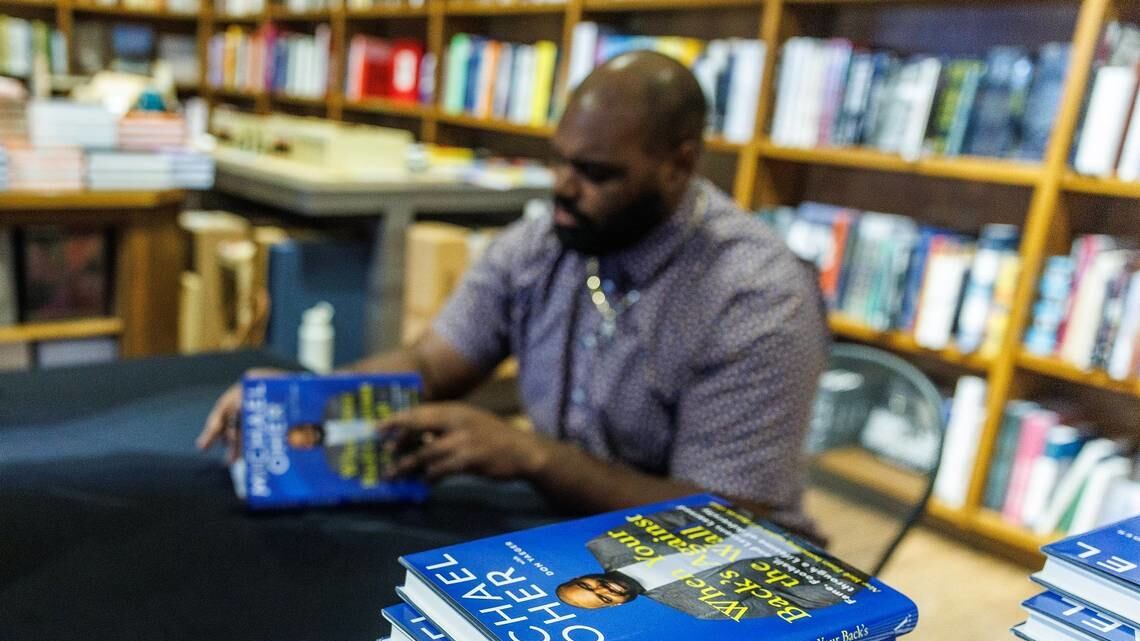 Michael Oher autographs his book in Coral Gables, Florida, Aug. 23, 2023.
