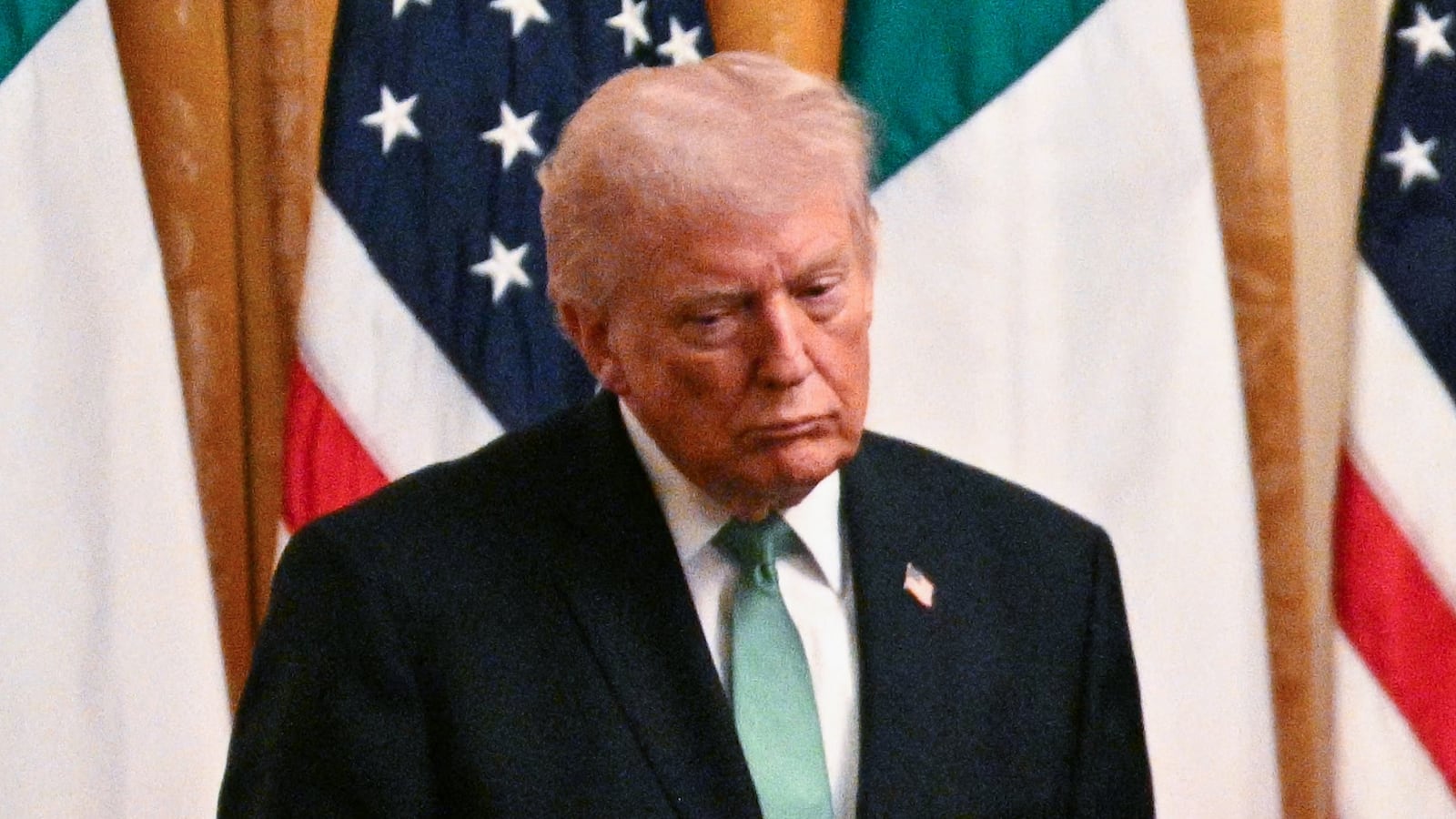US President Donald Trump looks at a bowl of shamrocks presented to him by Irish Prime Minster Micheal Martin on the occasion of St. Patrick's Day in the East Room of the White House in Washington, DC, on March 17, 2026. (Photo by Jim WATSON / AFP via Getty Images)