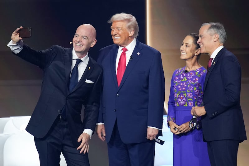 FIFA President Gianni Infantino takes a selfie during the FIFA World Cup 2026 Official Draw with President Donald Trump, Mexican President Claudia Sheinbaum, and Canadian Prime Minister Mark Carney at the John F. Kennedy Center for the Performing Arts December 05, 2025 in Washington, DC.