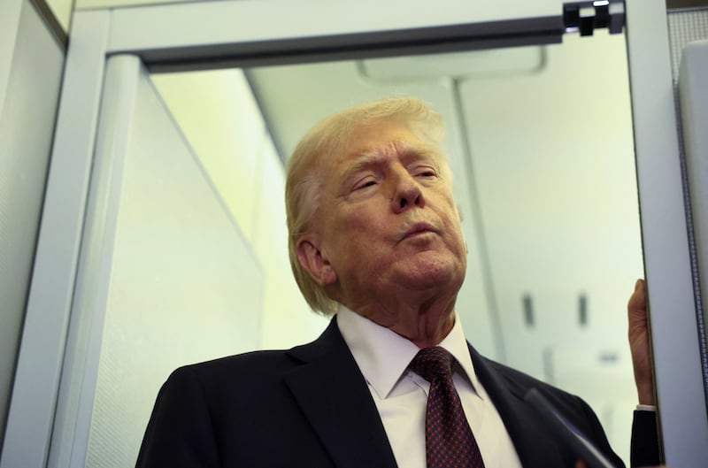 U.S. President Donald Trump speaks to reporters aboard Air Force One on a flight back to Washington March 15, 2026. REUTERS/Kevin Lamarque