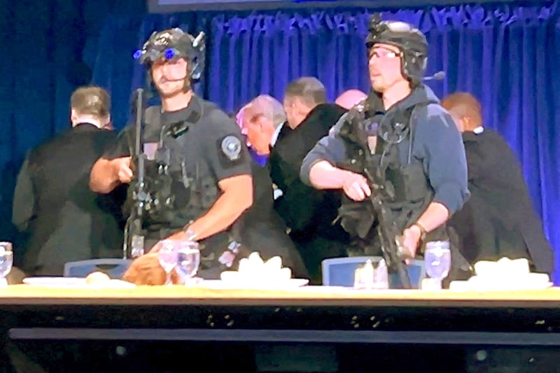 U.S. President Donald Trump is escorted out after a man opened fire with a shotgun on security personnel outside the room, during the annual White House Correspondents' Association dinner in Washington, D.C., U.S., April 25, 2026, in this still image from video.