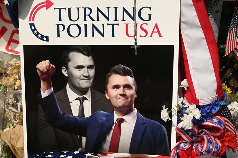 A pile of flowers, candles, and photos placed outside the original Turning Point USA office in Lemont, founded by Charlie Kirk, on Sunday, September 21, 2025.