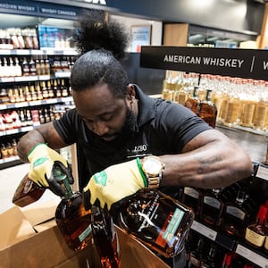 A worker removes U.S. alcohol from a shelf