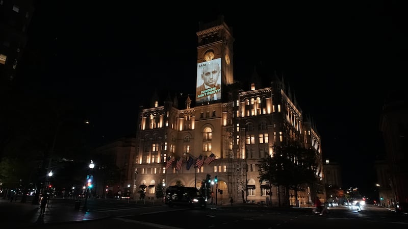 Stephen Miller's face is projected on the Old Post Office tower that was once the site of Trump International Hotel in Washington DC.