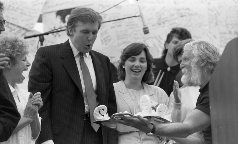 Trump in black and white looking at an object.