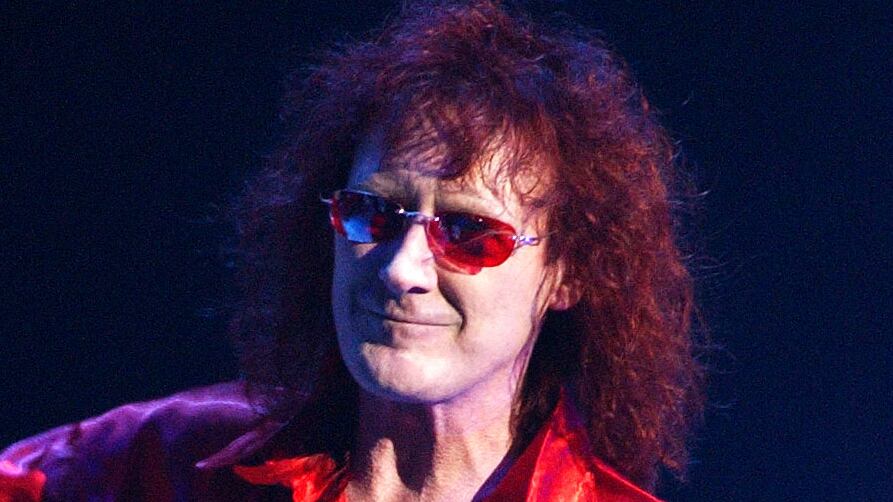 A photograph of Colin Burgess performing live on stage on September 16, 2002 in Sydney, Australia.