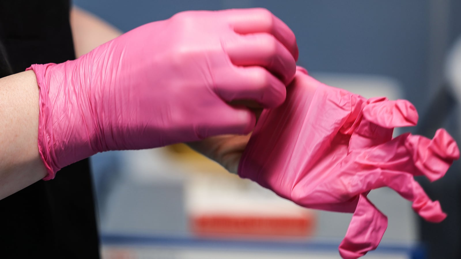 A surgical nurse puts on gloves in the operating room