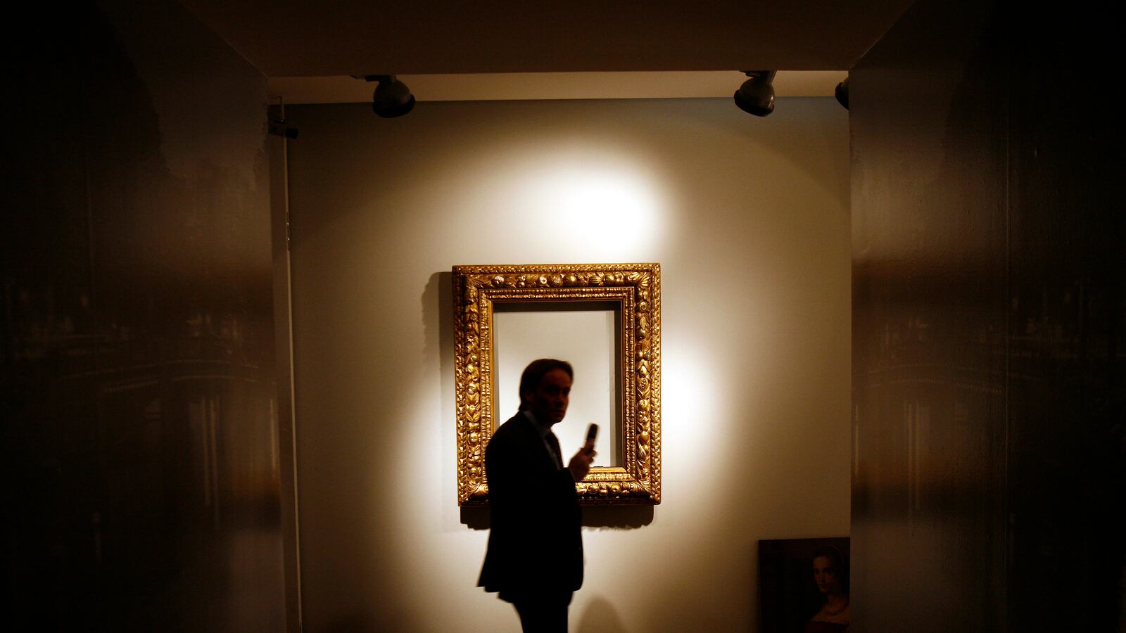 Man walks by a frame with no photo inside of it.