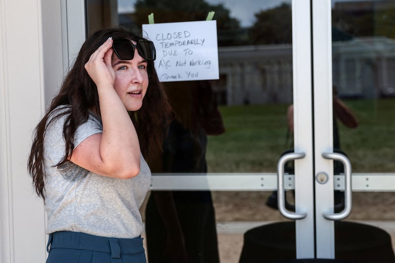 A woman leaves an exhibit that closed because of broken air-conditioning during a period of extreme heat in the region.