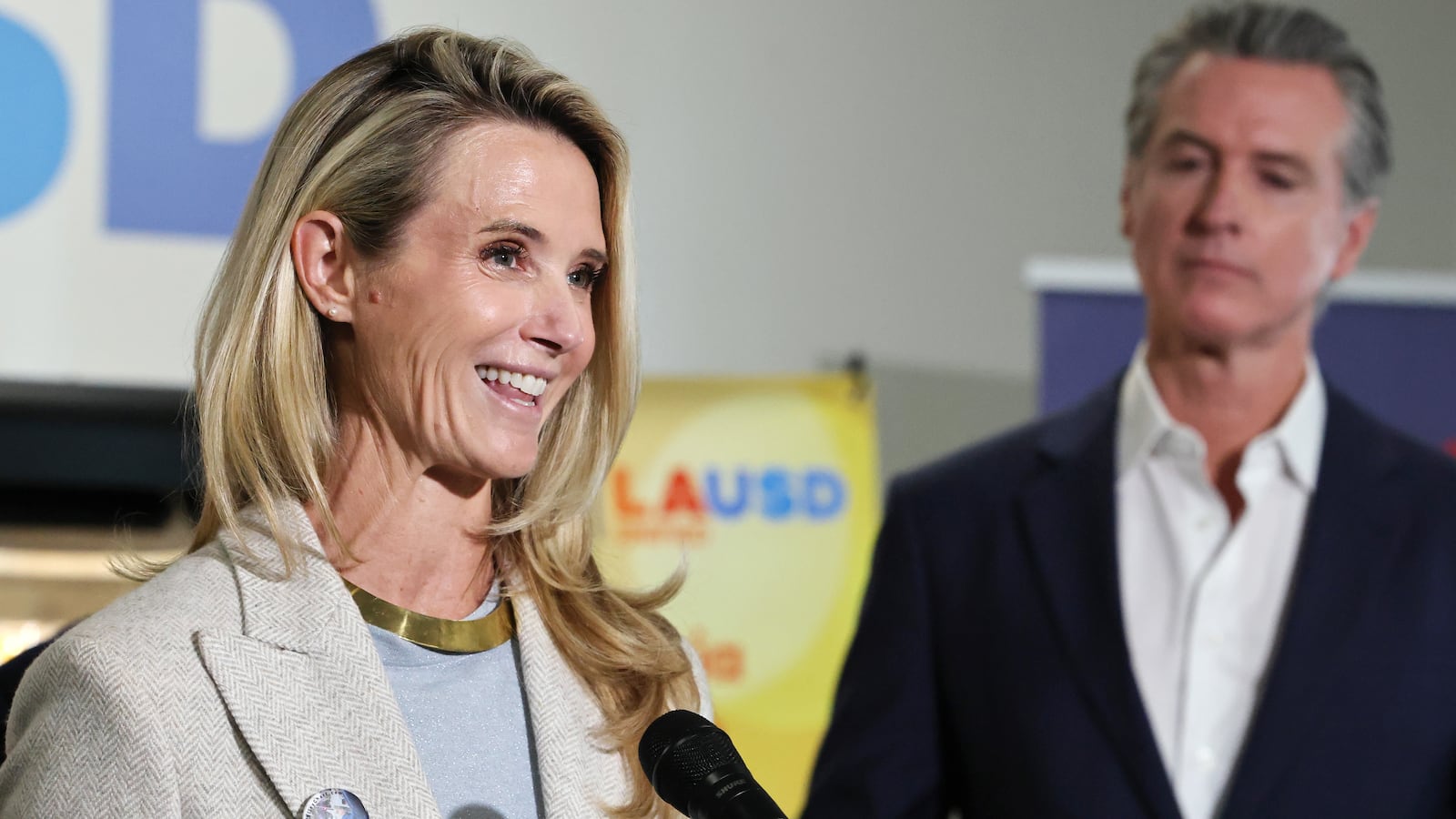 California Governor Gavin Newsom looks on as his wife Jennifer Siebel Newsom speaks at Belvedere Middle School before he signed legislation aimed at improving kids' nutrition and health across California on October 8, 2025 in Los Angeles, California.