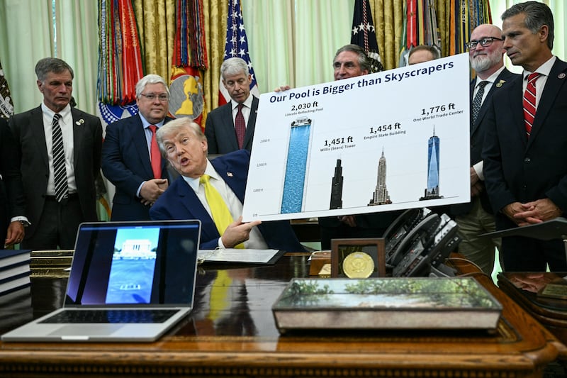 President Donald Trump holds a chart showing that the Reflecting Pool on the National Mall is taller than skyscrapers as he speaks in the Oval Office of the White House in Washington, DC on June 4, 2026.