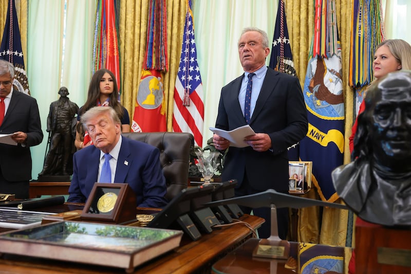 Health and Human Services Secretary Robert F. Kennedy Jr. (2nd-R), accompanied by (L-R) National Institutes of Health Director Jay Bhattacharya, Jayme Leagh Franklin with the The Conservateur, U.S. President Donald Trump, and Deputy Assistant to the President for Domestic Policy Dr. Heidi Overton (R), speaks before Trump signs an executive order calling for childhood vaccine shots to be spaced out into separate visits during an event in the Oval Office of the White House on Aug. 10, 2026 in Washington, DC.