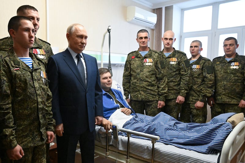 In this pool photograph distributed by the Russian state agency Sputnik, Russia's President Vladimir Putin (3rdL) poses as he visits servicemen who were wounded during the Russian military action in Ukraine, at a military hospital in Moscow on October 29, 2025. (Photo by Kristina Kormilitsyna / POOL / AFP) (Photo by KRISTINA KORMILITSYNA/POOL/AFP via Getty Images)