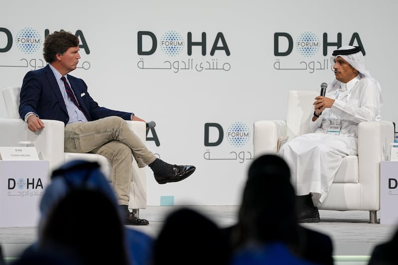 DOHA, QATAR - DECEMBER 07: Qatari Prime Minister and Foreign Minister Mohammed bin Abdulrahman Al Thani (R) answers questions from journalist Tucker Carlson (L) during the 'Newsmaker Interview' session held as part of the Doha Forum 2025 in Doha, Qatar on December 07, 2025. (Photo by Ahmet Turhan Altay/Anadolu via Getty Images)