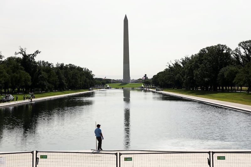 A worker stands beside the Lincoln Memorial Reflecting Pool, which has been painted blue at the directive of U.S. President Donald Trump, ahead of America 250, on the National Mall in Washington, D.C., U.S., June 9, 2026.