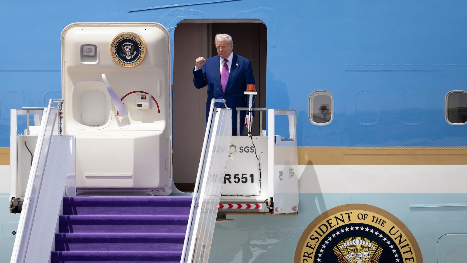 President Donald Trump gestures as he exits his plane upon arriving at the airport in Riyadh, Saudi Arabia on May 13, 2025.
