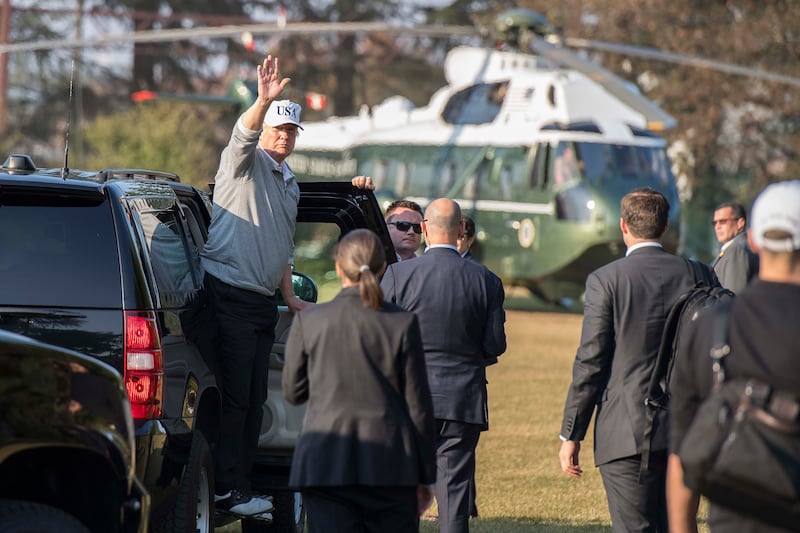 President Donald Trump waves to the press before golfing in Japan in 2017.
