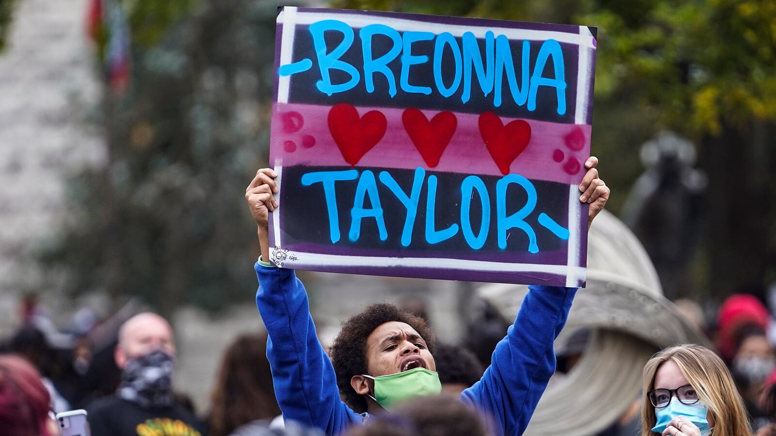 A protester holds a Breonna Taylor sign.