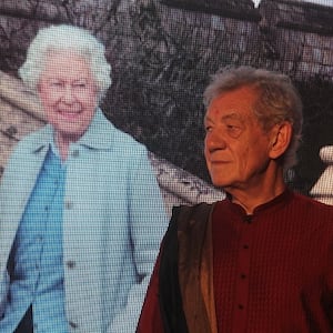 Ian McKellen (L) stands next to a life-sized image of a smiling Queen Elizabeth II