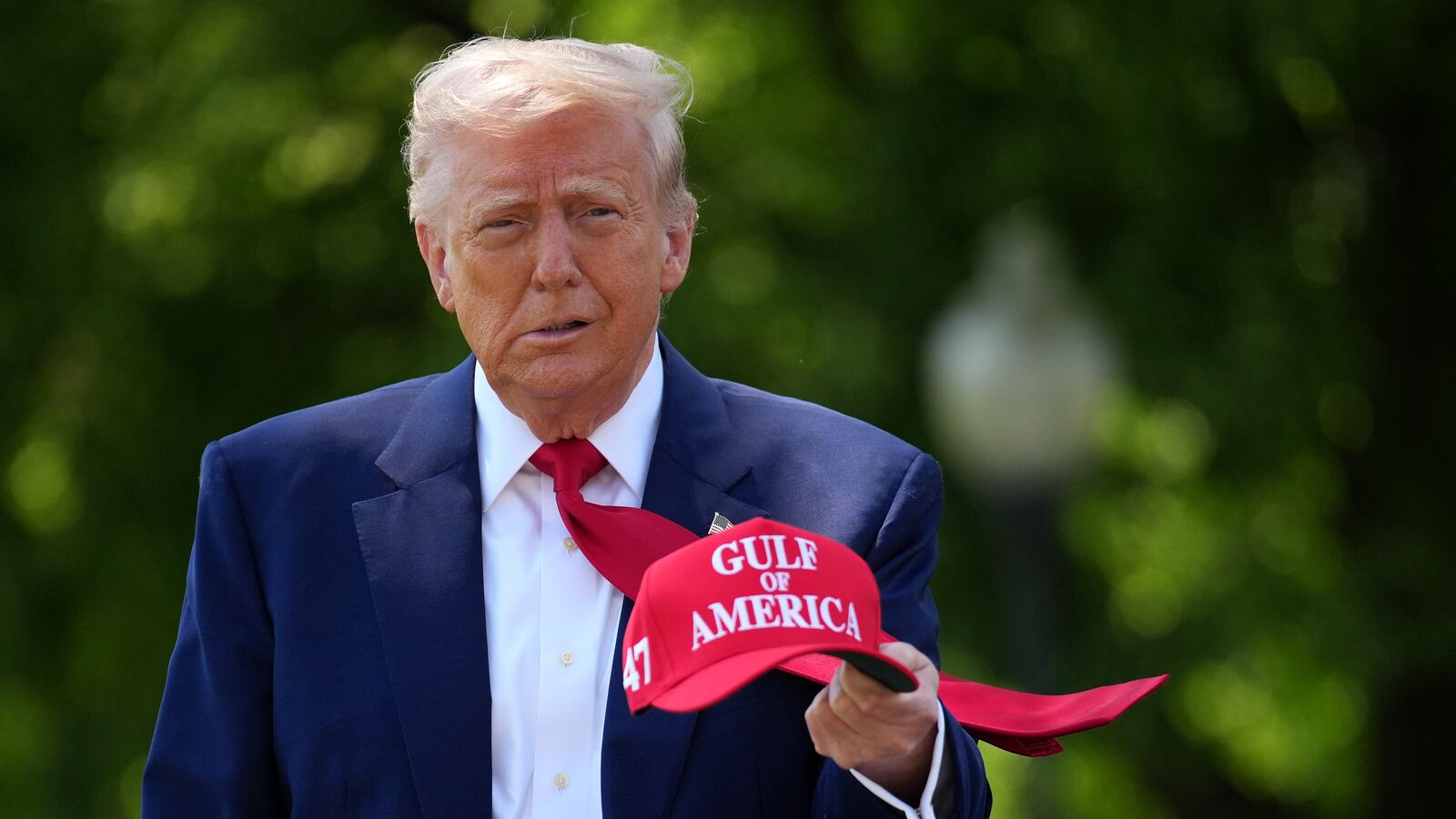 President Donald Trump holds a hat as he walks to speak to members of the media before boarding Marine One on the South Lawn of the White House on April 29, 2025 in Washington, DC.