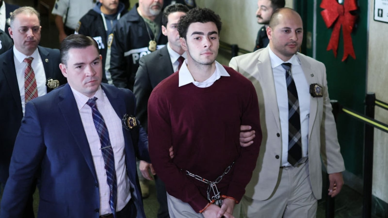 Luigi Nicholas Mangione arrives at Manhattan Criminal Court in New York, flanked by a contingent of NYPD officers.