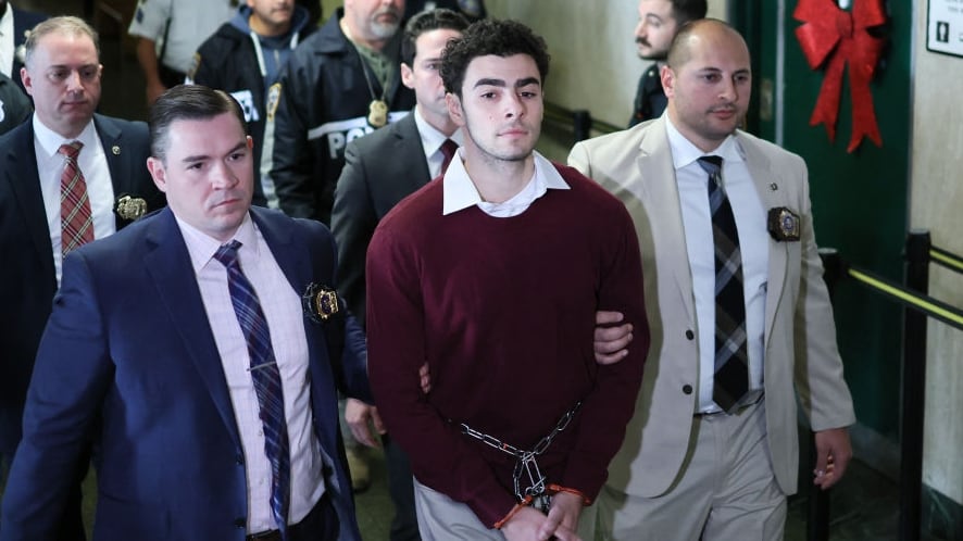 Luigi Nicholas Mangione arrives at Manhattan Criminal Court in New York, flanked by a contingent of NYPD officers.