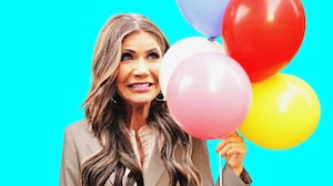 Kristi Noem making an awkward face holding balloons