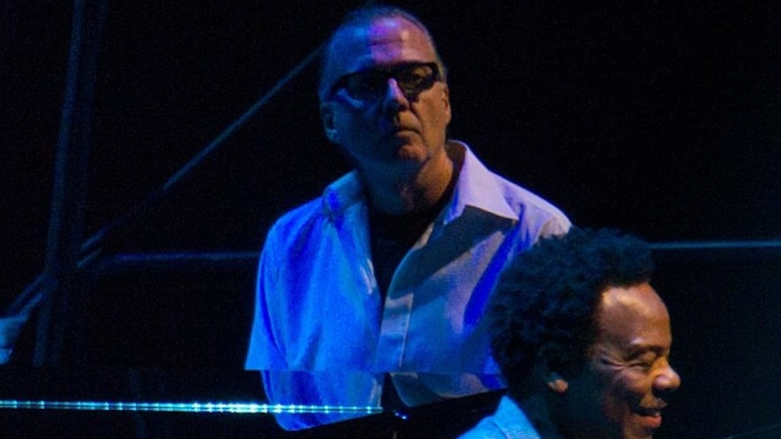 Jim Beard plays piano in a dark setting.