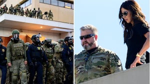 Kristi Noem looks down at federal agents and protesters