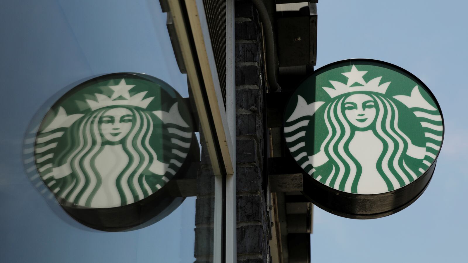 A Starbucks logo hangs outside of one of the 8,000 Starbucks-owned American stores that will close around 2 p.m. local time on Tuesday as a first step in training 175,000 employees on racial tolerance in New York, U.S., May 29, 2018.