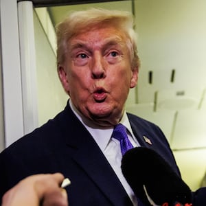 IN FLIGHT - FEBRUARY 06: U.S. President Donald Trump reacts after a reporter tells him that U.S. Vice President J.D. Vance was booed during the Opening Ceremony of the 2026 Winter Olympics during a gaggle with reporters while aboard Air Force One on February 6, 2026 en route to Palm Beach, Florida. The President is spending the weekend at Mar-a-Lago, his private club. (Photo by Samuel Corum/Getty Images)