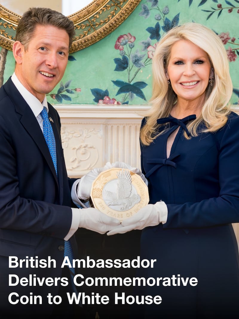 The two ambassadors hold the commemorative coin on Monday.