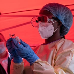 TOPSHOT - A nurse wears protective medical clothing and prepares a syringe by drawing a dose from a vaccine vial during the launch of an Ebola trial vaccination campaign at Mulago Referral Hospital in Kampala on February 3, 2025. Uganda started an Ebola Sudan virus vaccination trial on February 3, 2024, four days after an outbreak was confirmed, the WHO announced, beginning with those deemed at highest risk of the disease. (Photo by Badru Katumba / AFP) (Photo by BADRU KATUMBA/AFP via Getty Images)