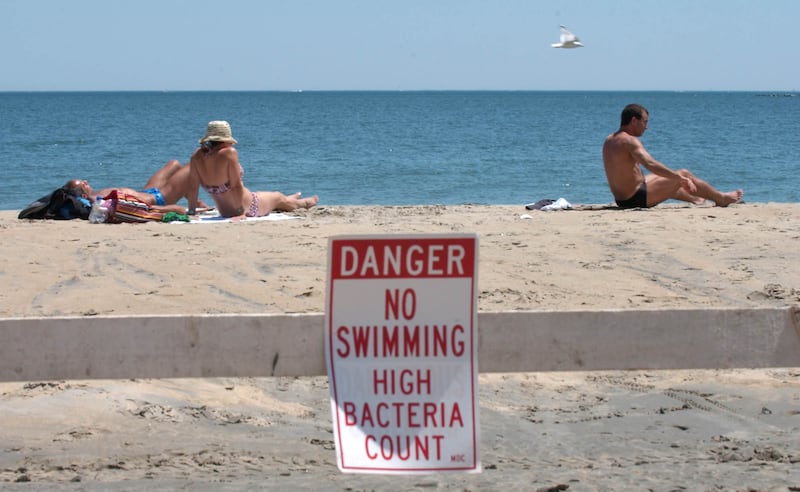 Signs posted at Rever Beach warn swimmers of contaminated water.