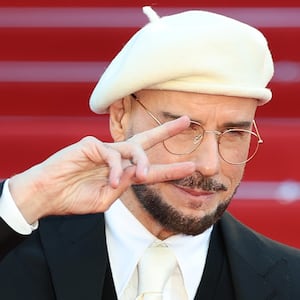 John Travolta attends the "Karma" screening in a white beret during the 79th annual Cannes Film Festival in 2026.