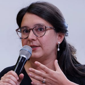 Bari Weiss holds a microphone up to his mouth in a photo 