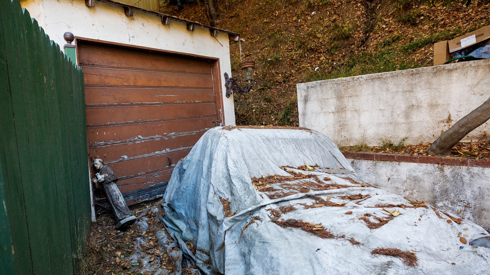 Jesuit statue and a covered vehicle sit in the driveway below a home where authorities are investigating a residential fire which took the life of eccentric millionaire Will Rothschild on November 28, 2024 in Hollywood Hills California. The fire began on Wednesday evening.