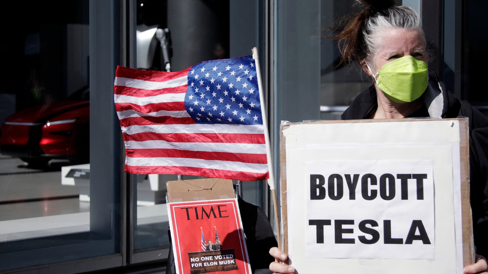People participate in a "TeslaTakedown" protest against Elon Musk outside of a Tesla dealership in New York, March 1, 2025.