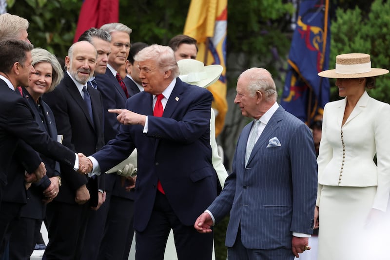 U.S. President Donald Trump gestures to some of his officials and VIP guests as he arrives with first lady Melania Trump, Britain's King Charles and Queen Camilla for the ceremony on the South Lawn of the White House in Washington, D.C., U.S., April 28, 2026. REUTERS/Suzanne Plunkett