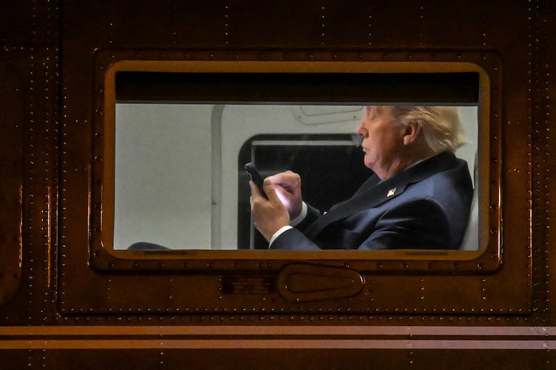 US President Donald Trump uses a cellphone