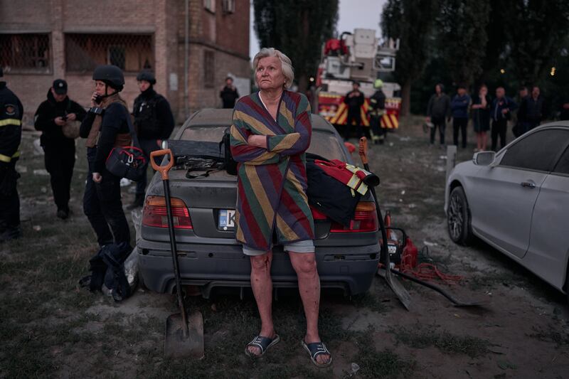 A person reacts as rescuers work at the site of a residential building hit by a Russian missile on August 28, 2025 in Kyiv, Ukraine.