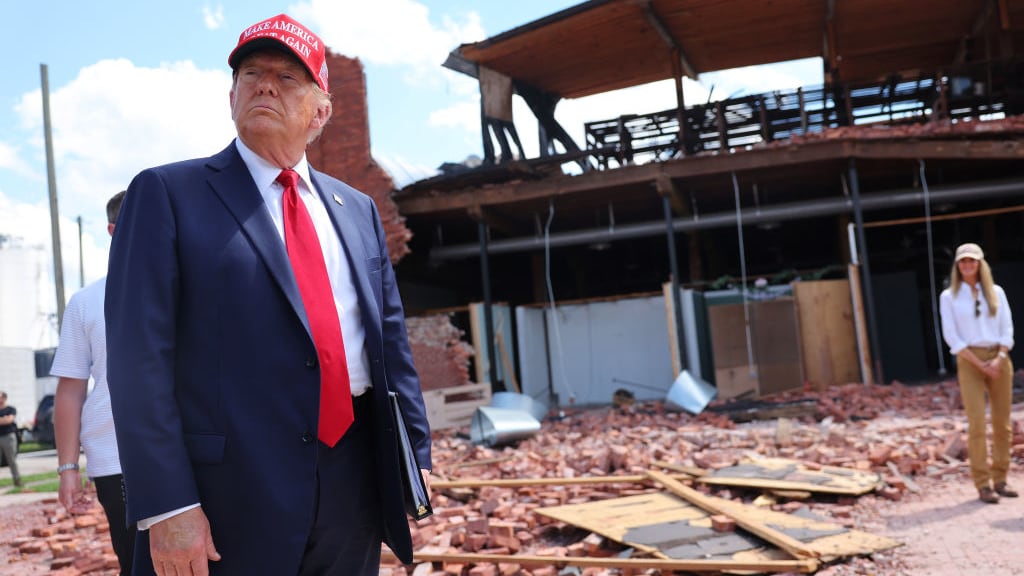 Former President Donald Trump listens to a question as he visits Chez What Furniture Store which was damaged during Hurricane Helene.